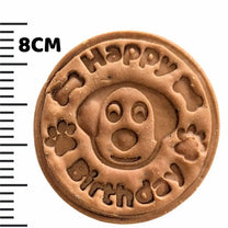 Dog birthday biscuit next to meassuring tape