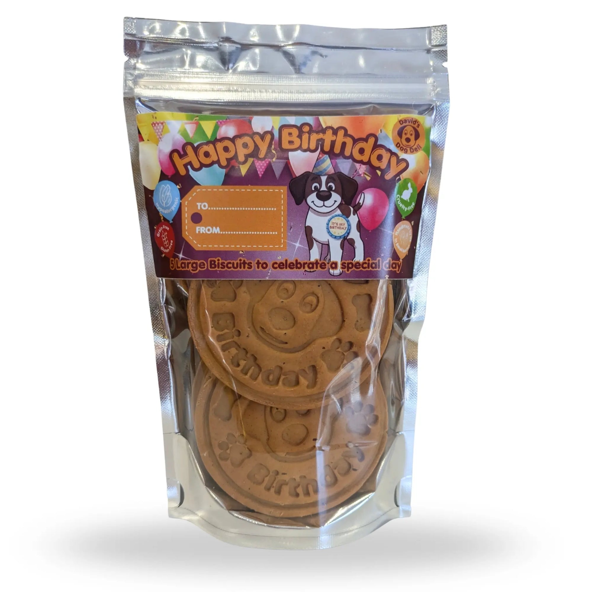 A clear plastic stand-up pouch containing round dog treats, with a colorful 'Happy Birthday' label on the front. The package is photographed on a plain white background.