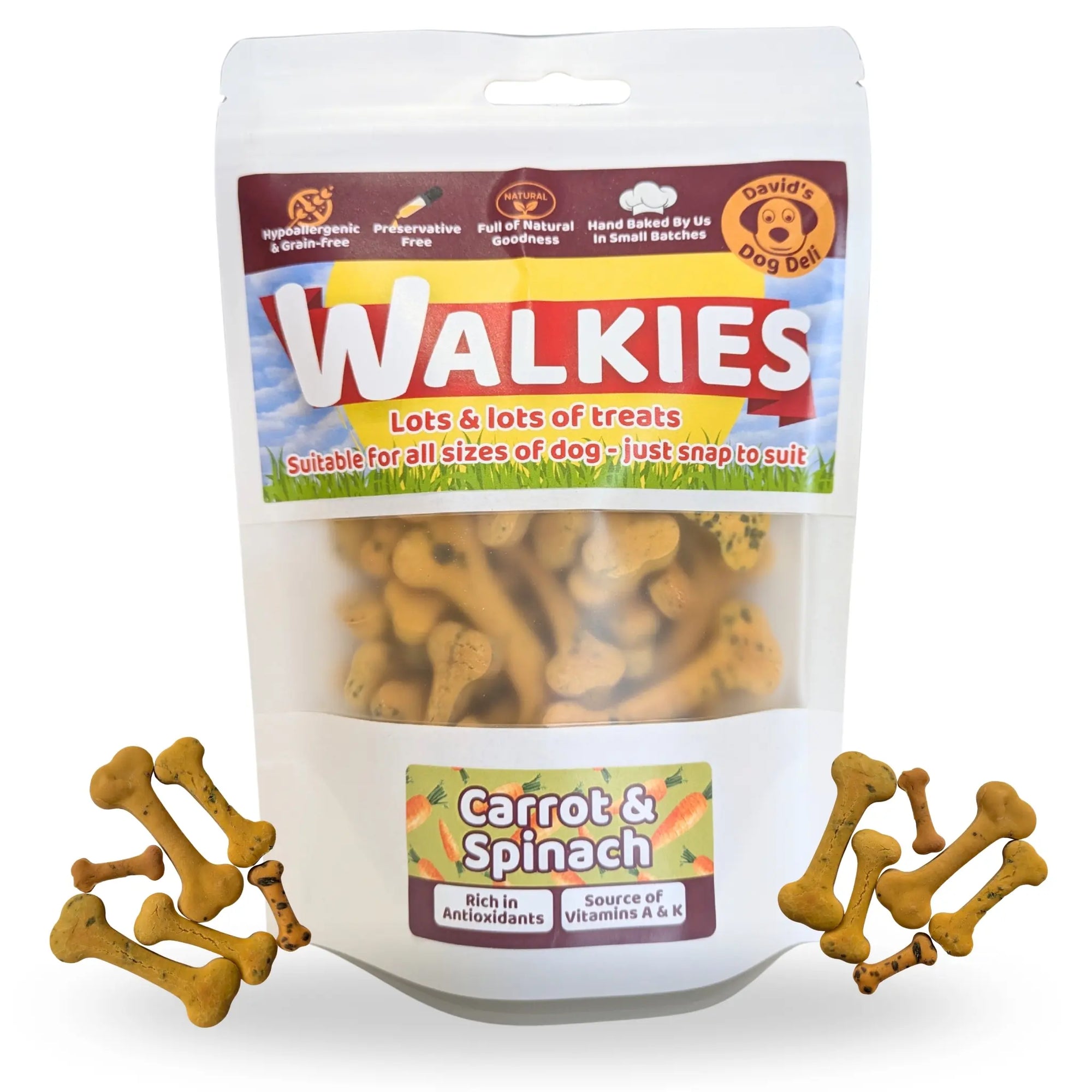 A stand-up pouch of Walkies dog treats, labeled 'Carrot & Spinach,' with several bone-shaped treats scattered around the base on a white background.